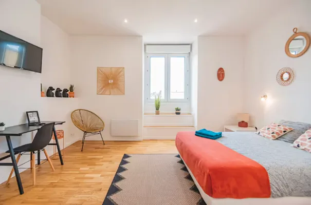 Chambre lumineuse avec parquet, grand lit et coin bureau